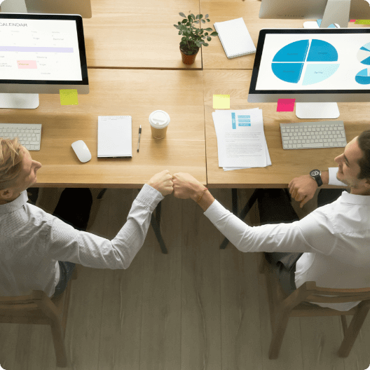 Two young male colleagues fist bump